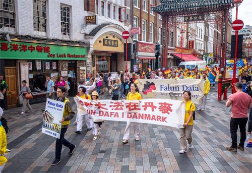 '图2～3：法轮功学员的游行队伍经过伦敦中国城'
