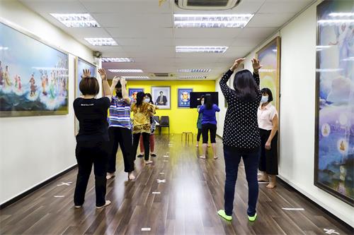 '图1：华语班的新学员学习法轮功功法动作。'