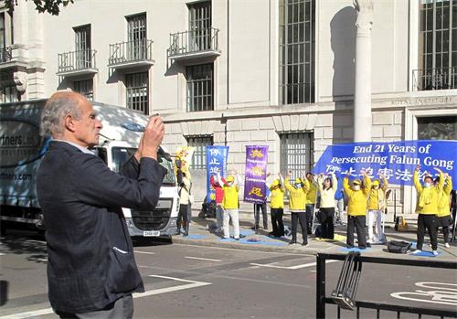 '图4：二零二零年十月一日，法轮功学员在中使馆前集体炼功的场面吸引了路过的伦敦医生安东尼·希尔弗斯通（Anthony Silverstone）'