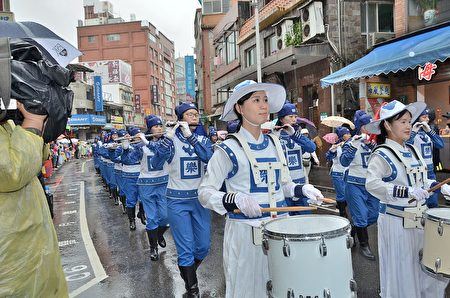 '图1～3：法轮功学员组成的台湾法轮大法天国乐团不畏风雨，参加淡水环境艺术节踩街活动，受到民众热烈欢迎。'
