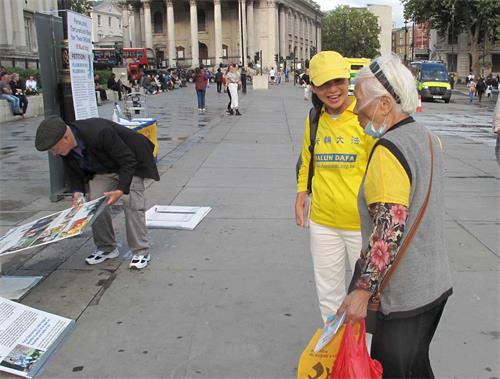 '图11：当天的活动快结束时，一位住在唐人街的八十七岁华人梅珍女士走过来赞扬法轮功学员讲真相活动做得好。'