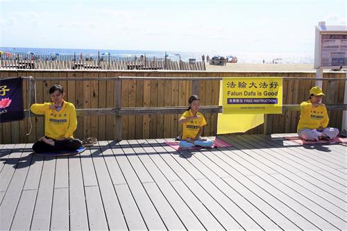 '图1～4：法轮功学员在海滨木板路上的功法展示'