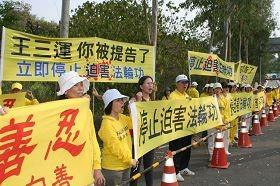 台南市议员曾秀娟（左三）声援法轮功，一起拉横幅对王三运大声呼口号