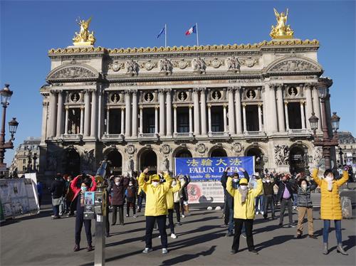 '图6：二月二十八日下午，法轮功学员在巴黎歌剧院广场进行了讲真相和征签的活动。图为法轮功学员演示功法'