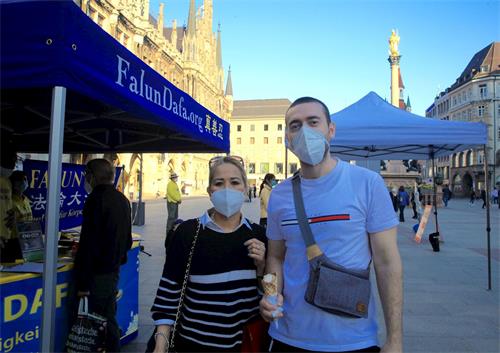 '图4：二零二一年三月三十日在玛琳广场（Marienplatz），伊马姆维奇（Sanad Imamovic）和女友阿科斯巴（Maria Theresa Acosta）签名制止中共活摘法轮功学员器官。'