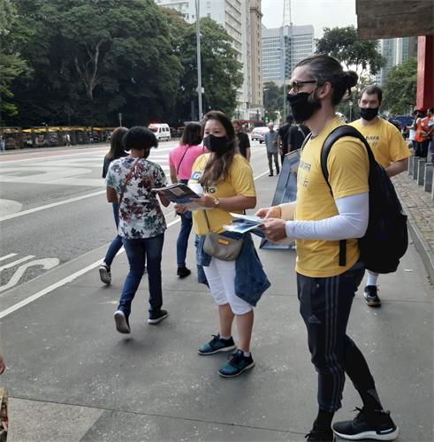 '图2：巴西学员在圣保罗人大道向民众们传递真相'