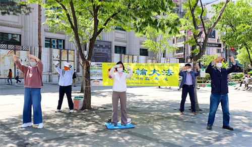 '图5：韩国法轮功学员在驻韩中共大使馆附近集体炼功。'