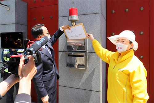 '图6：记者会结束时，韩国法轮大法佛学会代表将声明书投入驻韩中共大使馆的信箱。'