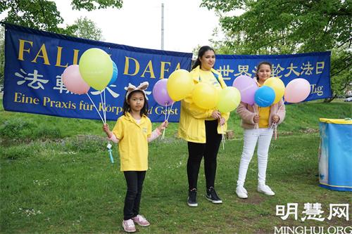 '图3：大法小弟子萨拉（Sara K.，中）和其他孩子一起参加了2021年5月13日在纽伦堡沃德湖畔的法轮大法日庆祝活动。'