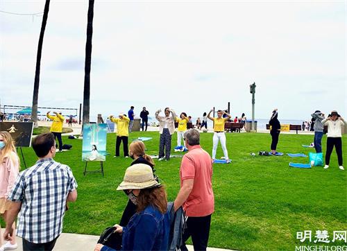 '图1～2：在刚过去的是美国阵亡将士纪念日（Memorial Day） 长周未，法轮功学员来到加洲橙县的拉古娜海滩（Laguna Beach）炼功洪法、传播法轮功真相。'