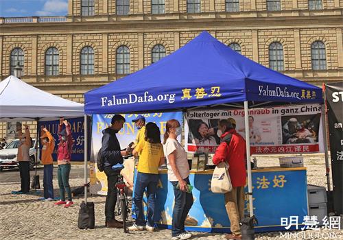 '图1～2：二零二一年五月二十九日，法轮功学员在慕尼黑马克西——约瑟夫广场（Max-Joseph-Platz）举办讲真相活动，不少民众驻足了解。'
