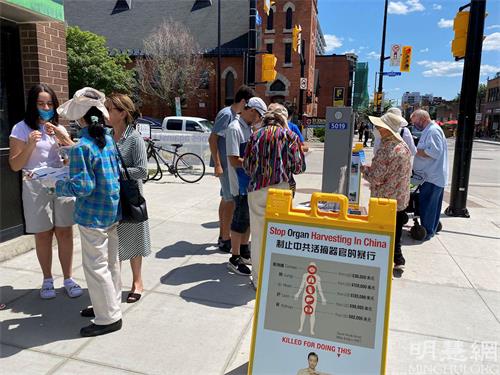 '图1～2：渥太华人在市中心的街道上，通过签名等方式表达对法轮功的支持。'